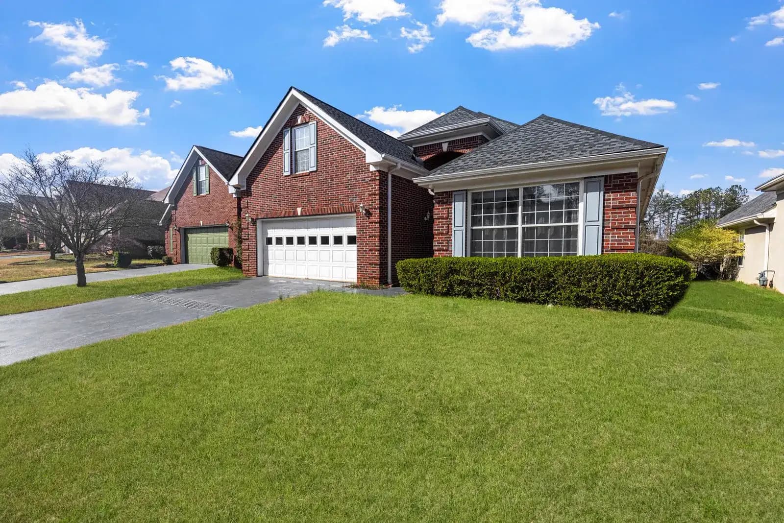 Modern suburban homes with green front lawns in spring